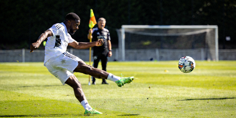 足球运动员在训练中练习任意球射门技巧